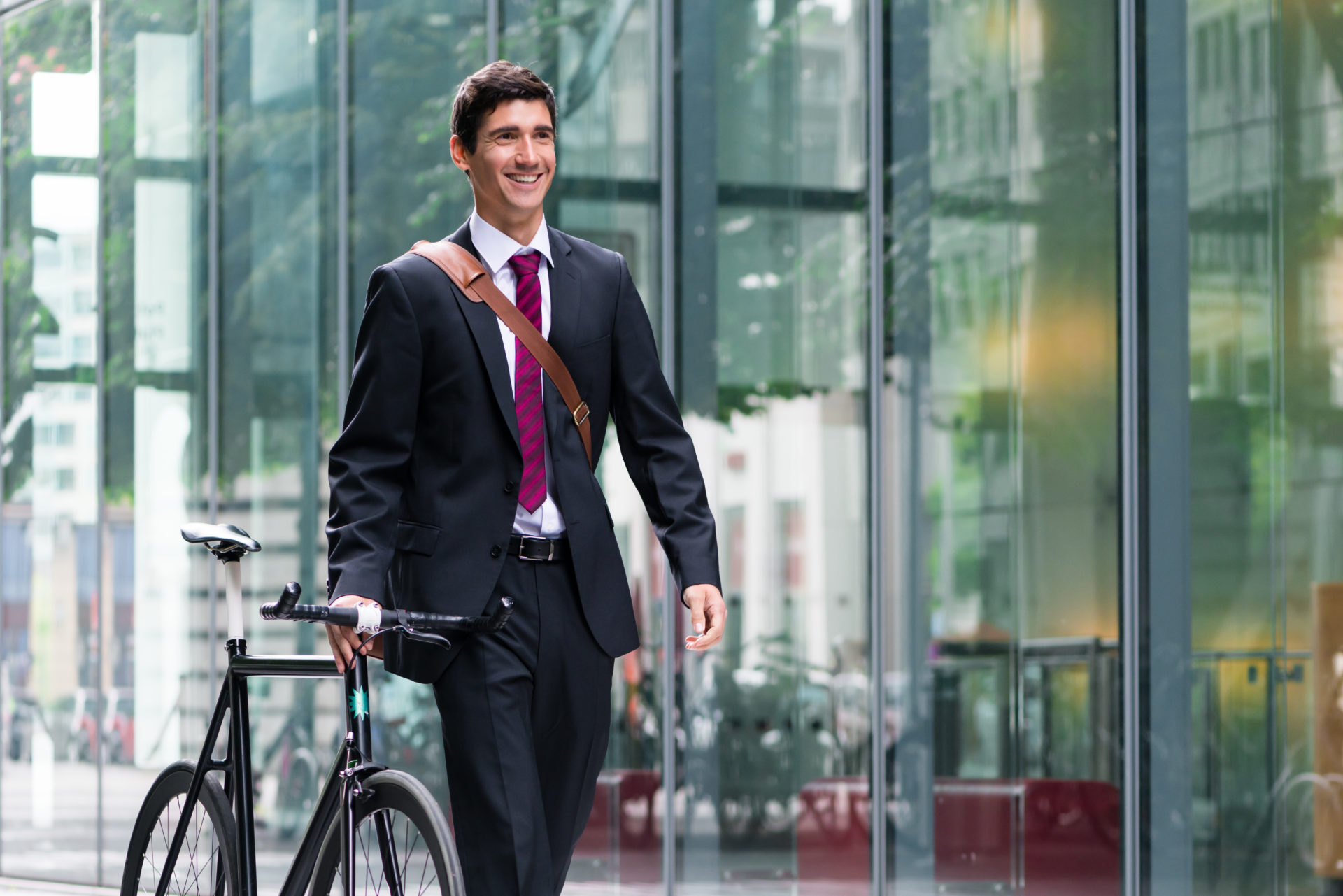 Man in suit holding bike